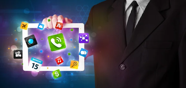 Empresario sosteniendo una tableta con modernas aplicaciones coloridas e iconos —  Fotos de Stock