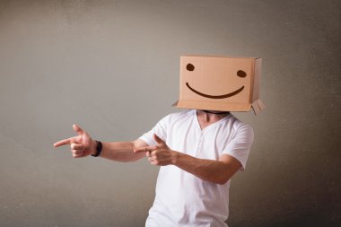 genç adam smiley ile kafasına bir karton kutu ile el hareketi