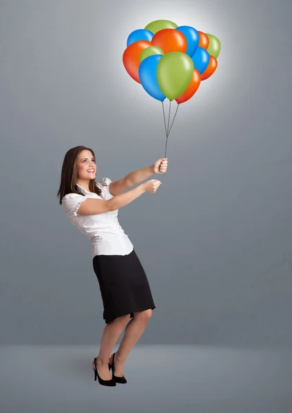 Mujer joven sosteniendo globos de colores — Foto de Stock