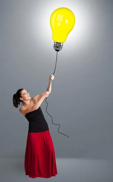 Pretty lady holding a light bulb balloon