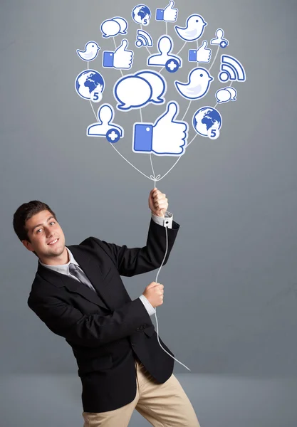 Attractive man holding social icon balloon — Stock Photo, Image