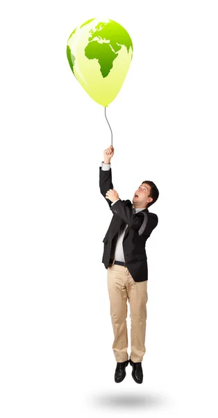 Handsome man holding a green globe balloon — Stock Photo, Image