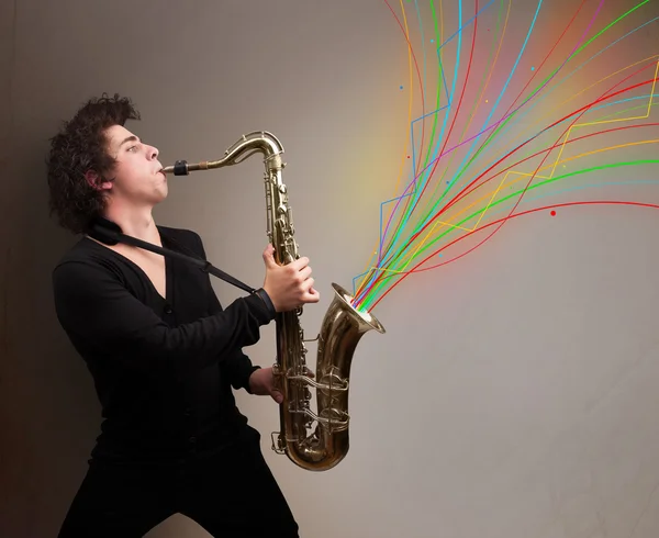 Attractive musician playing on saxophone while colorful abstract — Stock Photo, Image