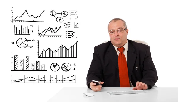 Empresário sentado na mesa com diagramas e segurando um mobileph — Fotografia de Stock