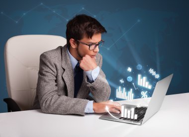 genç adam masada oturan ve diyagramları ile laptop yazarak ve