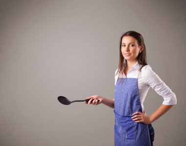 Güzel bir kadın kaşık tutuyor.