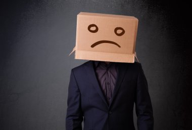 Young man with a brown cardboard box on his head with sad face clipart
