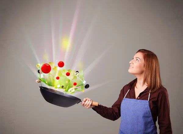 Jovem mulher cozinhar legumes frescos — Fotografia de Stock