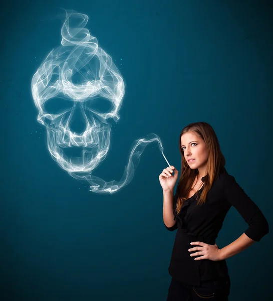 Young woman smoking dangerous cigarette with toxic skull smoke — Stock Photo, Image