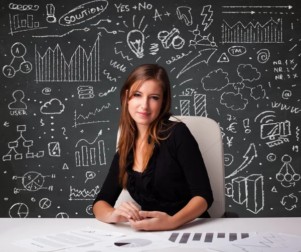 Geschäftsfrau sitzt am Schreibtisch mit Geschäftsplan und Symbolen — Stockfoto