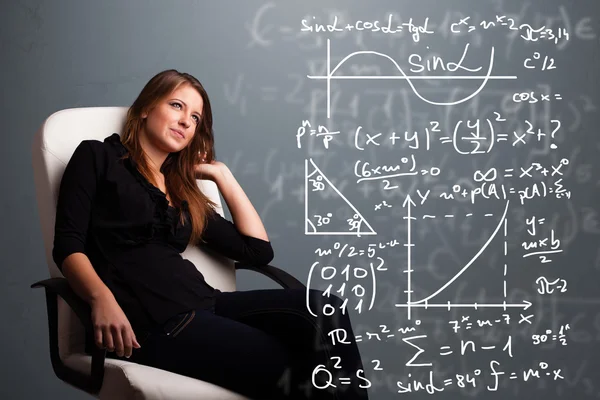 Vacker skolflicka tänker på komplexa matematiska tecken — Stockfoto