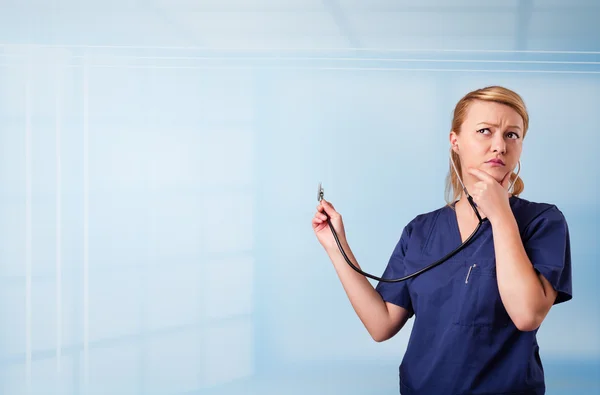 Graziosa infermiera in ospedale ascoltando vuoto copia spazio con sthe — Foto Stock