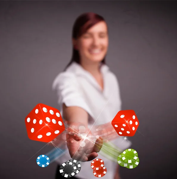 Young woman throwing dices and chips — Stock Photo, Image