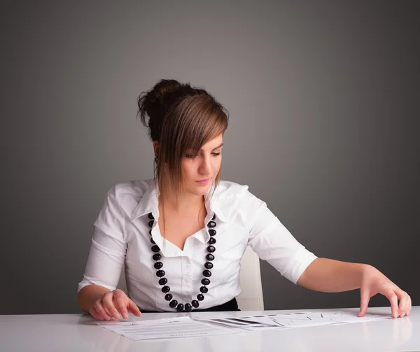 Zakenvrouw zit achter het bureau en doet papierwerk — Stockfoto