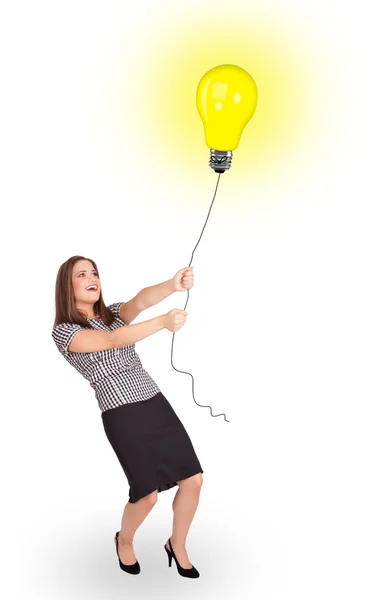 Lycklig kvinna som håller en glödlampa ballong — Stockfoto
