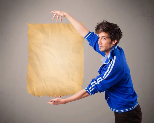 Young man presenting old paper copy space — Stock Photo, Image