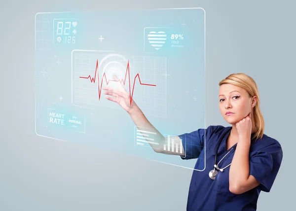 Young nurse pressing modern medical type of buttons — Stock Photo, Image
