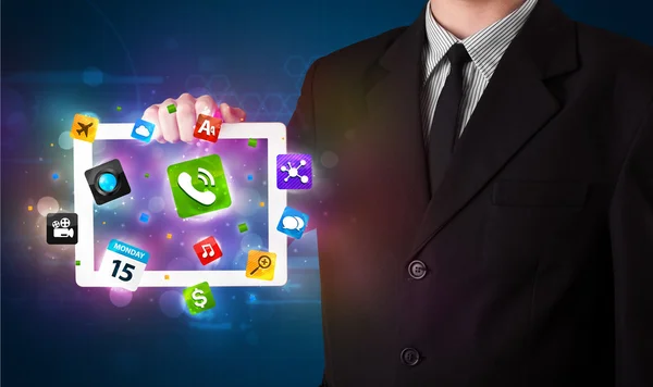 Empresário segurando um tablet com modernos aplicativos coloridos e ícones — Fotografia de Stock