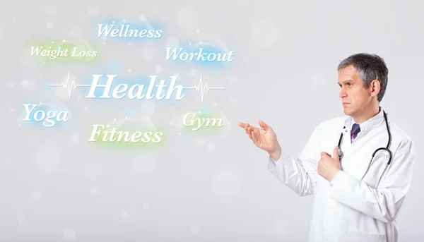 Clinical doctor pointing to health and fitness collection of wor — Stock Photo, Image