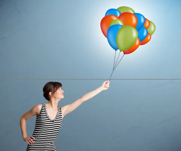 Junge Frau mit bunten Luftballons — Stockfoto