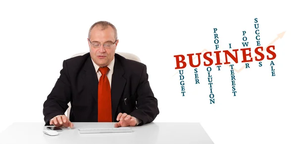 Businessman sitting at desk and typing on keyboard with word clo — Stockfoto