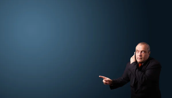 Hombre de negocios haciendo llamada telefónica y presentando espacio de copia — Foto de Stock