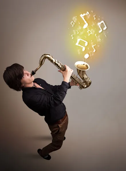 Красивый музыкант играет на саксофоне с музыкальными нотами — стоковое фото