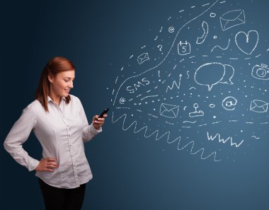 Çeşitli modern teknoloji simgeleriyle akıllı telefonda yazan kız