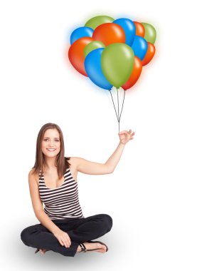 Genç bir kadın elinde renkli balonlar tutuyor.