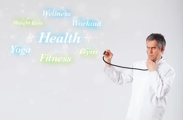 Clinical doctor pointing to health and fitness collection of wor — Stock Photo, Image