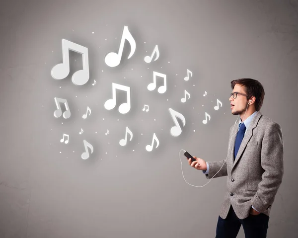 Attrayant jeune homme chantant et écoutant de la musique avec musical — Photo