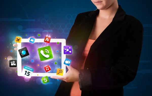 Lady hält ein Tablet mit modernen, bunten Apps und Symbolen in der Hand — Stockfoto