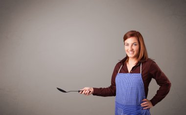 Güzel bir kadın kaşık tutuyor.