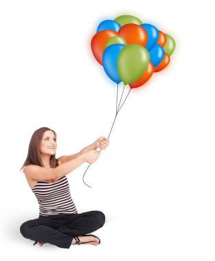 Genç bir kadın elinde renkli balonlar tutuyor.