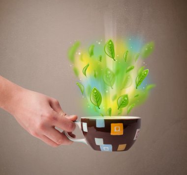 Yapraklı çay fincanı ve renkli soyut ışıklar