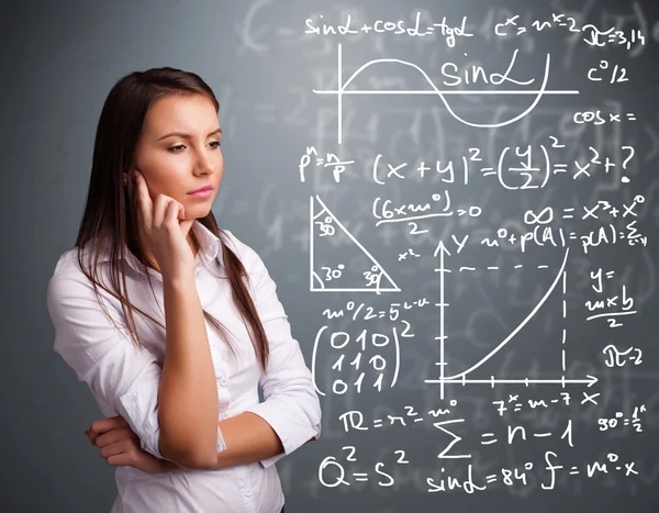 Hermosa chica de la escuela pensando en signos matemáticos complejos — Foto de Stock