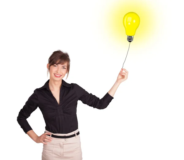 Lycklig kvinna som håller en glödlampa ballong — Stockfoto