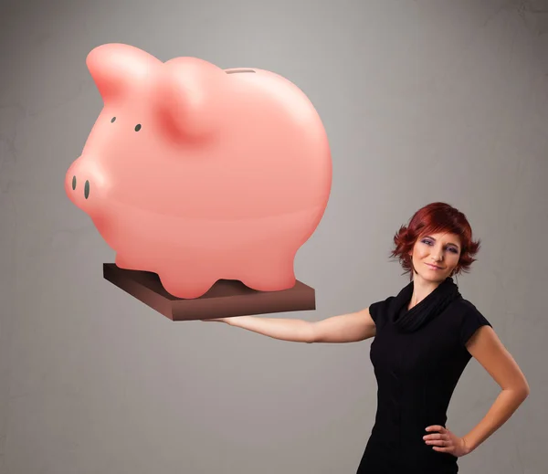 Young girl holding a huge savings piggy bank — Stock Photo, Image