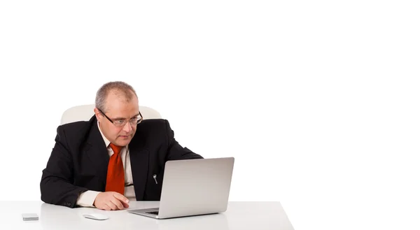 Geschäftsmann sitzt am Schreibtisch und sucht Laptop mit Kopierplatz — Stockfoto