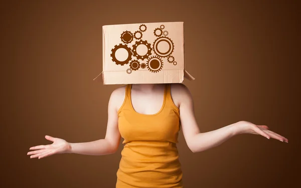 Mujer joven haciendo un gesto con una caja de cartón en la cabeza con un espolón — Foto de Stock