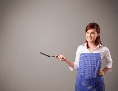 Güzel bir kadın kaşık tutuyor.