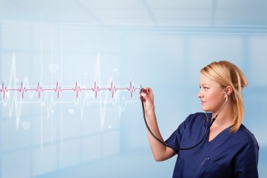 Güzel doktor kırmızı nabız ve kalp atışlarını dinliyor.
