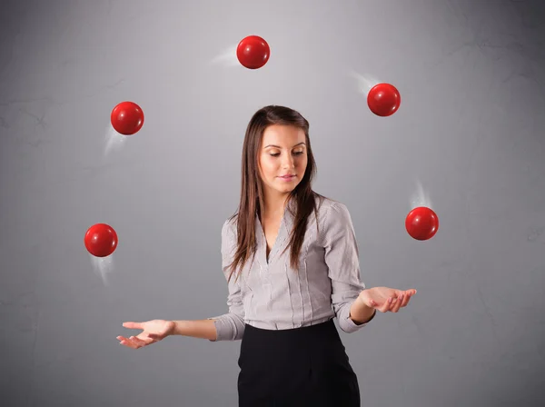 Giovane ragazza in piedi e giocoleria con le palle rosse — Foto Stock