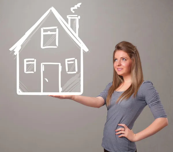 Young lady holding a huge drawn house — Stock Photo, Image