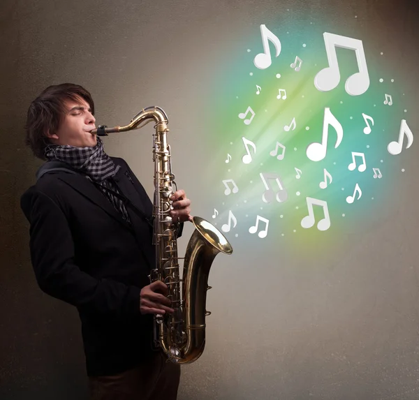 Young musician playing on saxophone while musical notes explodin — Stock Photo, Image