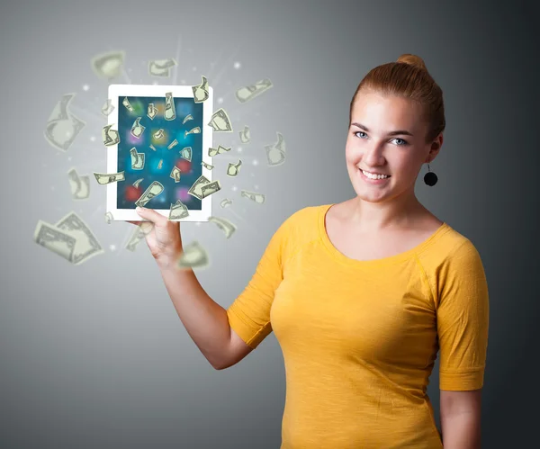 Giovane donna che tiene tablet con i soldi — Foto Stock