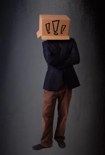 Junger Mann gestikuliert mit einem Karton auf dem Kopf mit Ausrufezeichen — Stockfoto