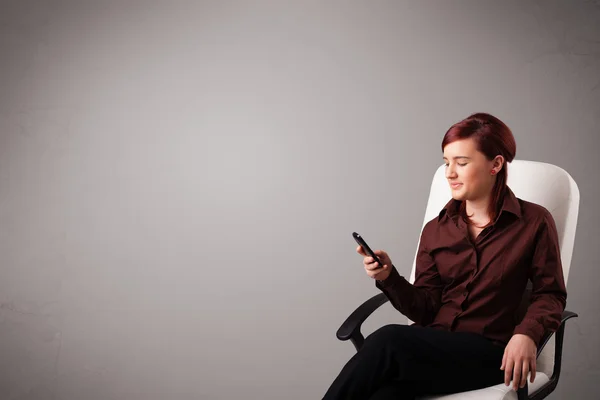 Νεαρή κυρία κάθεται και κρατώντας ένα τηλέφωνο με χώρο αντίγραφο — Φωτογραφία Αρχείου