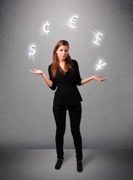 Młoda dama stojąca i żonglująca ikonami walut — Zdjęcie stockowe