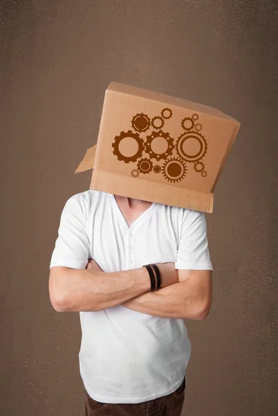 Jovem gesticulando com uma caixa de papelão na cabeça com esporão w — Fotografia de Stock